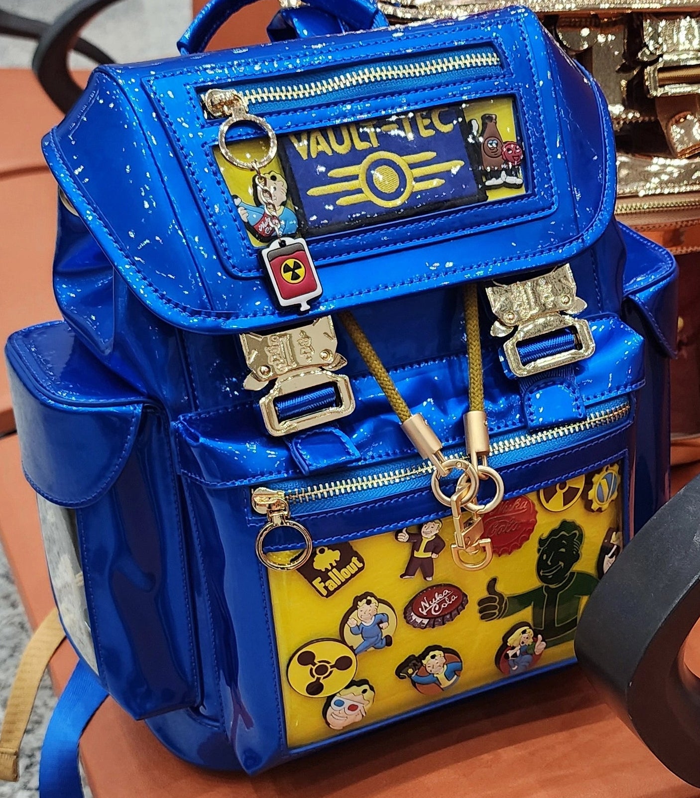 Blue ita backpack with video game themed enamel pins and keychains.