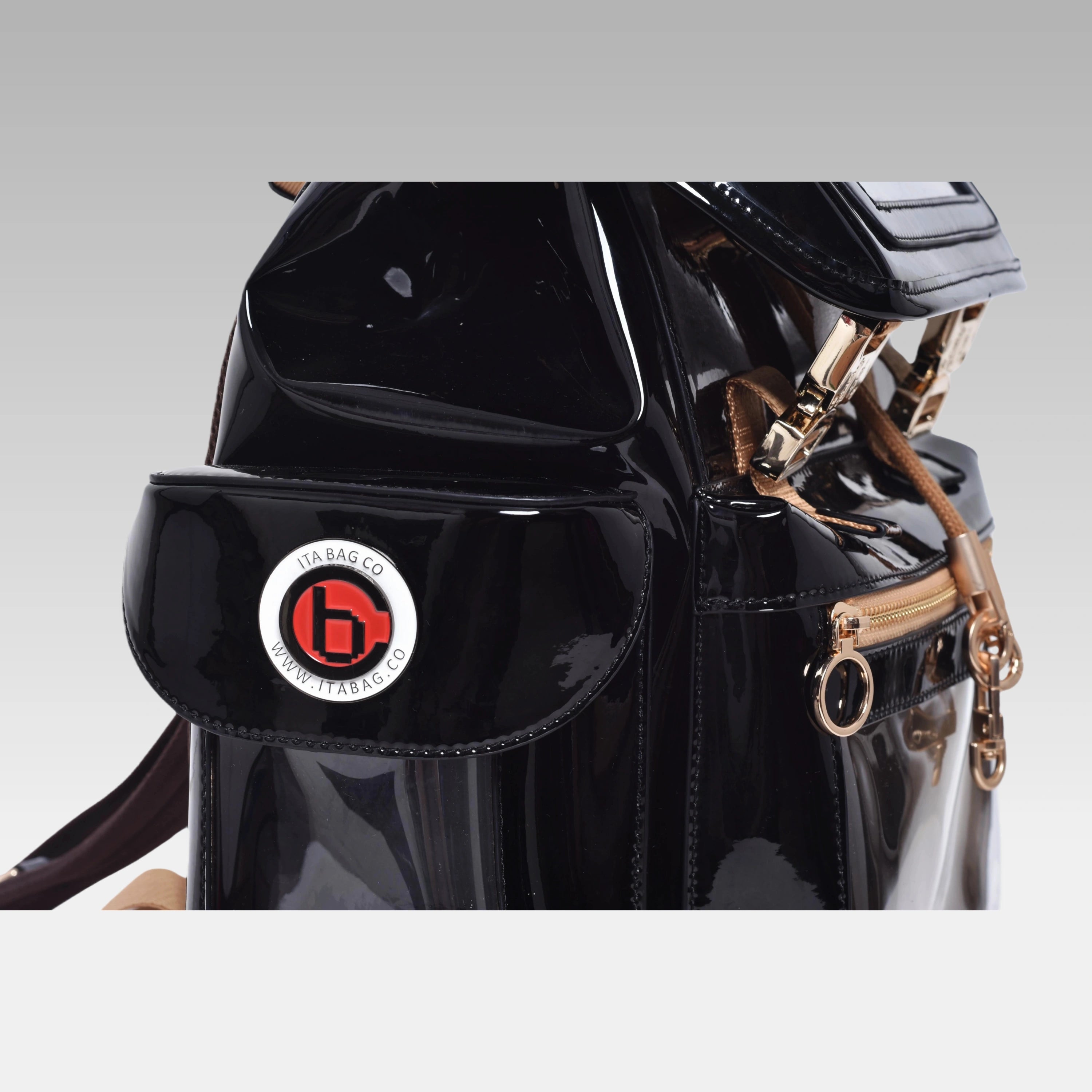 Close-up macro view of the custom hardware emblem on the Glossy Black Cyberpunk Ita Bag.