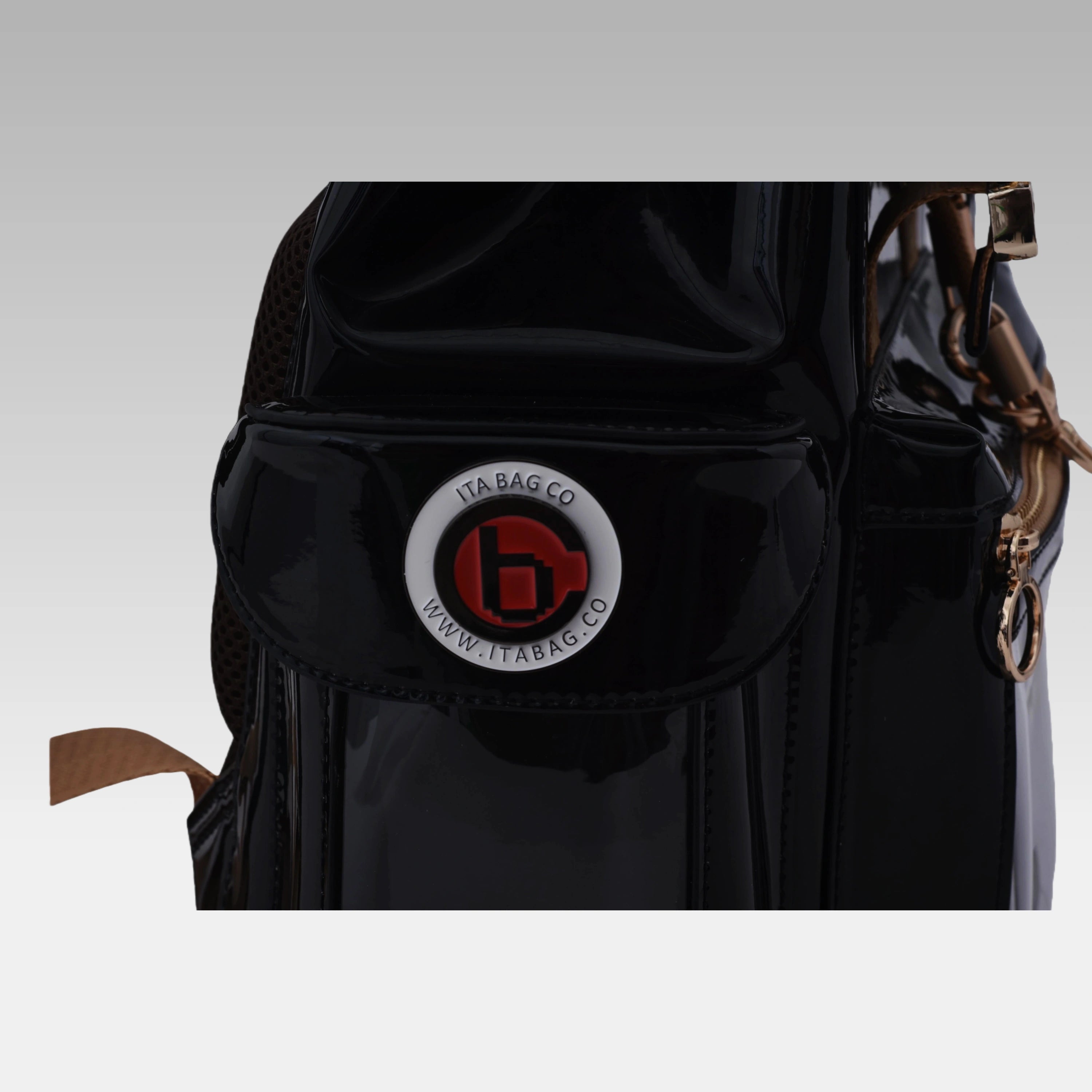 Close-up macro detail of the custom hardware emblem on the Glossy Black Cyberpunk Ita Bag Mini.